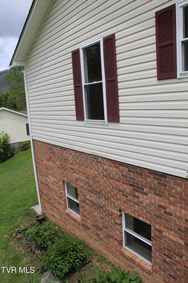view of home's exterior featuring brick siding and a yard