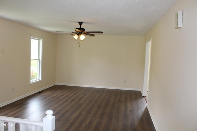 unfurnished room with dark wood finished floors, visible vents, baseboards, and ceiling fan