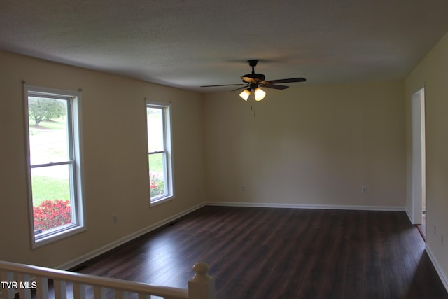 unfurnished room with baseboards, dark wood-style floors, and ceiling fan