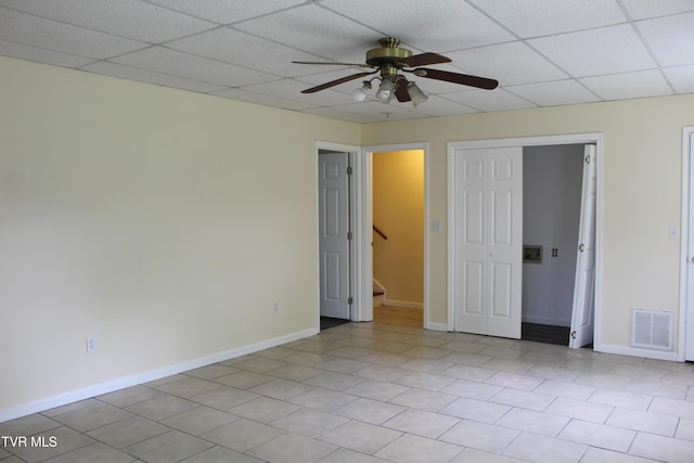unfurnished bedroom featuring baseboards, a paneled ceiling, visible vents, and a closet