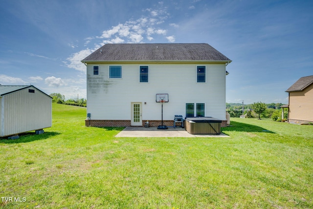 rear view of property featuring a storage shed, an outdoor structure, a hot tub, a yard, and a patio
