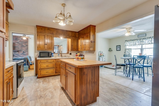 226 Delaney St, Bristol, TN 37620 - kitchen with electric stove, black microwave, butcher block countertops, brown cabinetry, and ceiling fan with notable chandelier