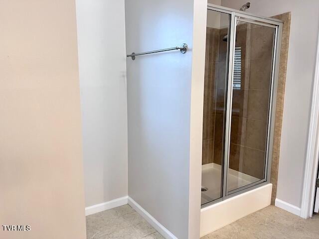 full bath with baseboards and tiled shower