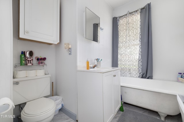 full bathroom featuring a freestanding bath, vanity, and toilet