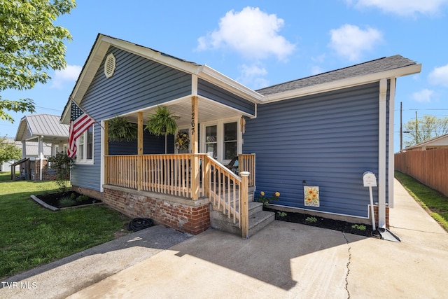 bungalow-style home with a porch, fence, and a front yard