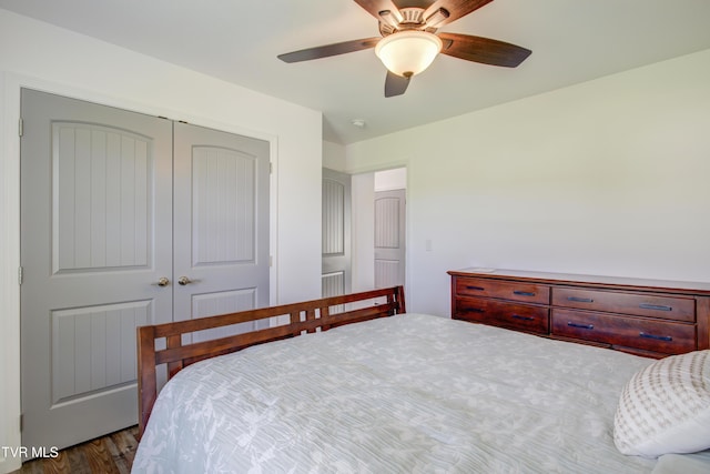 bedroom with a closet, dark wood-style floors, and ceiling fan