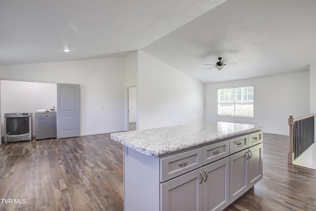 kitchen with independent washer and dryer, vaulted ceiling, open floor plan, gray cabinetry, and a ceiling fan