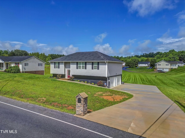 split foyer home featuring concrete driveway, a garage, and a front yard