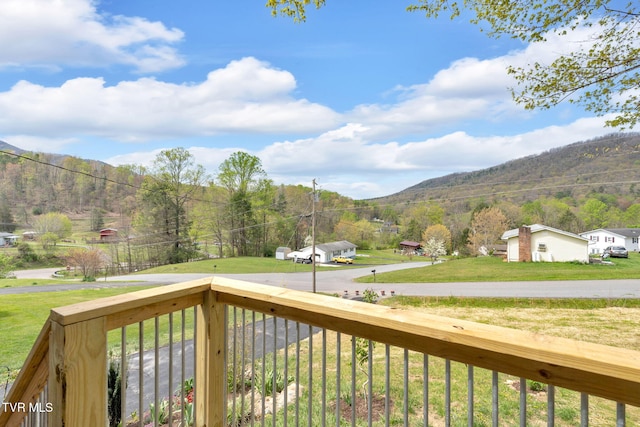 deck with a mountain view and a lawn