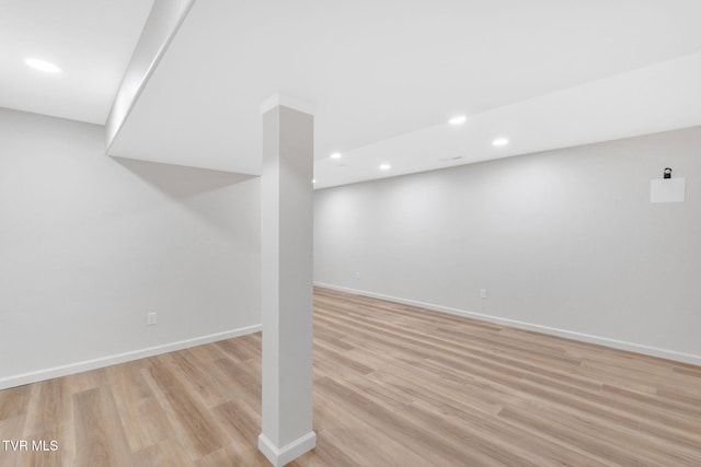 finished basement with recessed lighting, baseboards, and light wood-type flooring