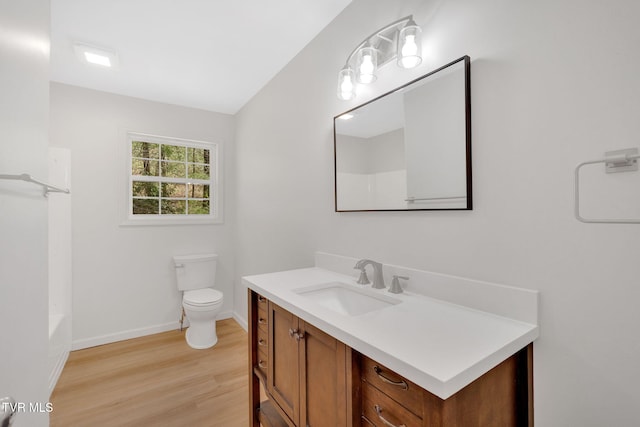 full bathroom featuring a shower, baseboards, toilet, wood finished floors, and vanity