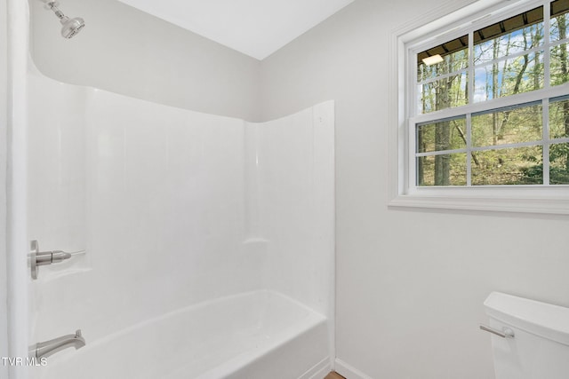 full bathroom featuring baseboards, toilet, and bathtub / shower combination