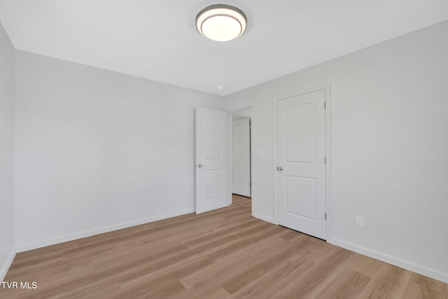 unfurnished bedroom with baseboards and light wood-style floors