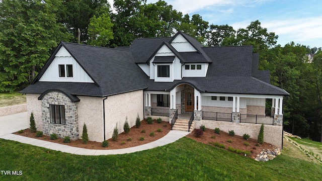 1093 Hawk Nest Ct, Jonesborough, TN 37659 - view of front of house with stone siding, covered porch, a front lawn, and roof with shingles