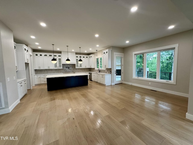 1093 Hawk Nest Ct, Jonesborough, TN 37659 - kitchen with a sink, baseboards, light countertops, a kitchen island, and decorative backsplash