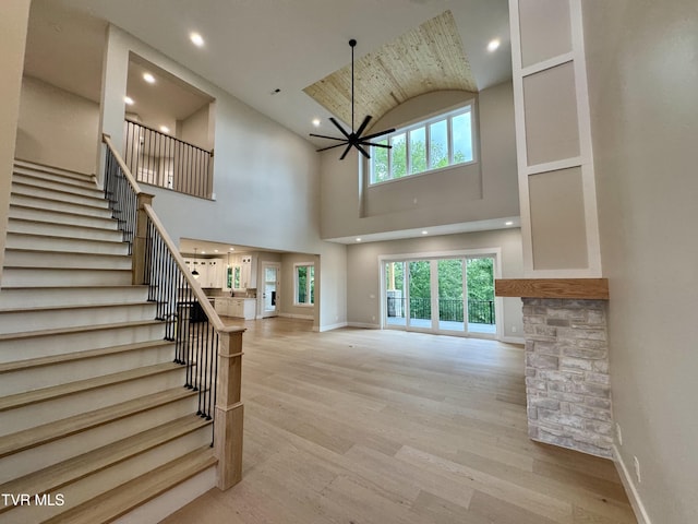 1093 Hawk Nest Ct, Jonesborough, TN 37659 - unfurnished living room featuring stairs, plenty of natural light, wood finished floors, baseboards, and high vaulted ceiling