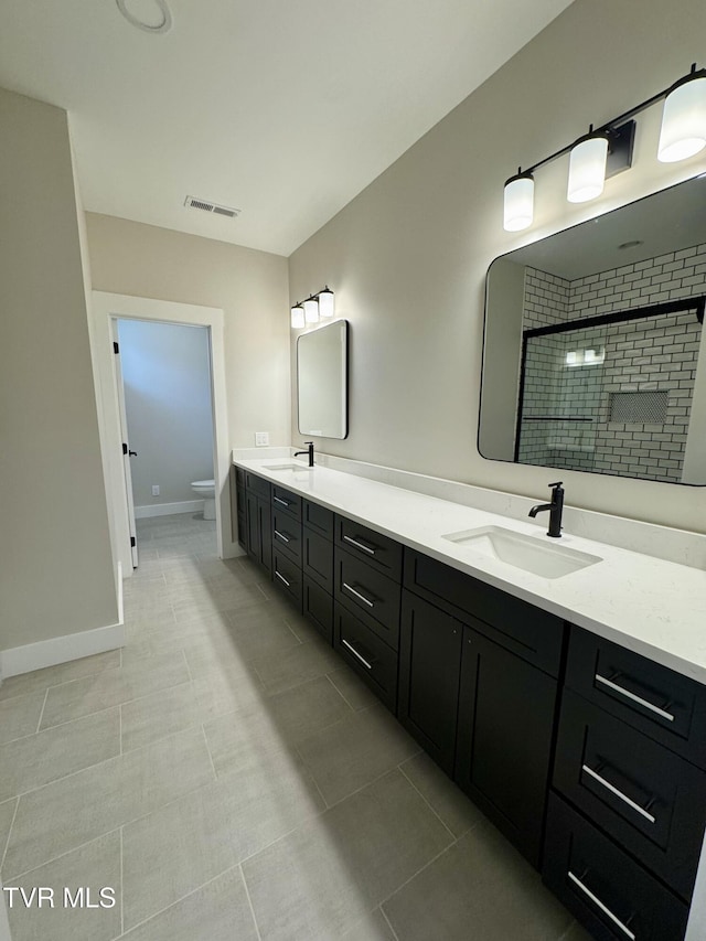 1093 Hawk Nest Ct, Jonesborough, TN 37659 - full bathroom featuring toilet, double vanity, a tile shower, tile patterned floors, and baseboards