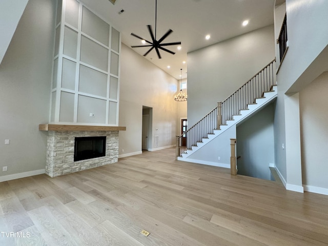 1093 Hawk Nest Ct, Jonesborough, TN 37659 - unfurnished living room with stairway, wood finished floors, a high ceiling, ceiling fan, and a stone fireplace