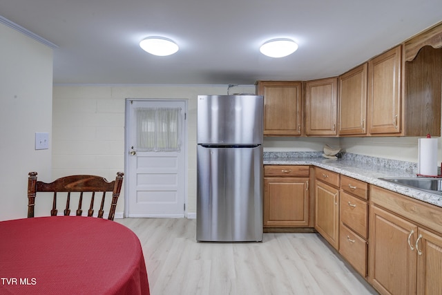 103 Dogwood Ln, Johnson City, TN 37604 - kitchen featuring brown cabinetry, light countertops, light wood-type flooring, and freestanding refrigerator