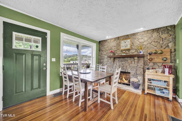 20 Chuckey College St, Chuckey, TN 37641 - dining room featuring a textured ceiling, hardwood / wood-style floors, a fireplace, baseboards, and ornamental molding