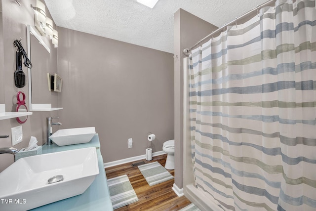 20 Chuckey College St, Chuckey, TN 37641 - bathroom with a sink, toilet, wood finished floors, a textured ceiling, and baseboards