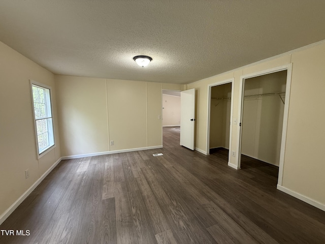 136 Gentry Mountain Rd, Erwin, TN 37650 - unfurnished bedroom with dark wood-style flooring, baseboards, multiple closets, and a textured ceiling