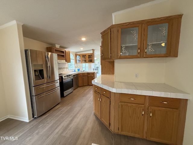 136 Gentry Mountain Rd, Erwin, TN 37650 - kitchen with backsplash, appliances with stainless steel finishes, brown cabinetry, and light wood-style floors