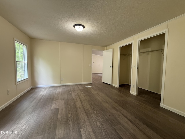 136 Gentry Mountain Rd, Erwin, TN 37650 - unfurnished bedroom with two closets, a textured ceiling, dark wood-style floors, and baseboards