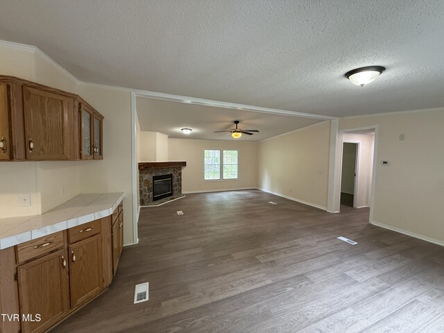 136 Gentry Mountain Rd, Erwin, TN 37650 - kitchen with brown cabinetry, a ceiling fan, a textured ceiling, and visible vents