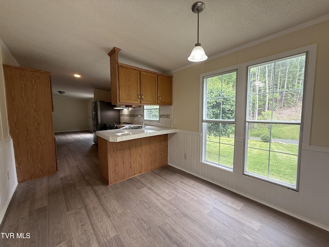 136 Gentry Mountain Rd, Erwin, TN 37650 - kitchen with brown cabinetry, a peninsula, wood finished floors, light countertops, and a textured ceiling
