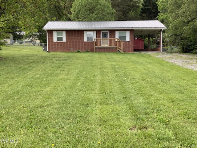 ranch-style house with a front lawn, metal roof, dirt driveway, brick siding, and fence