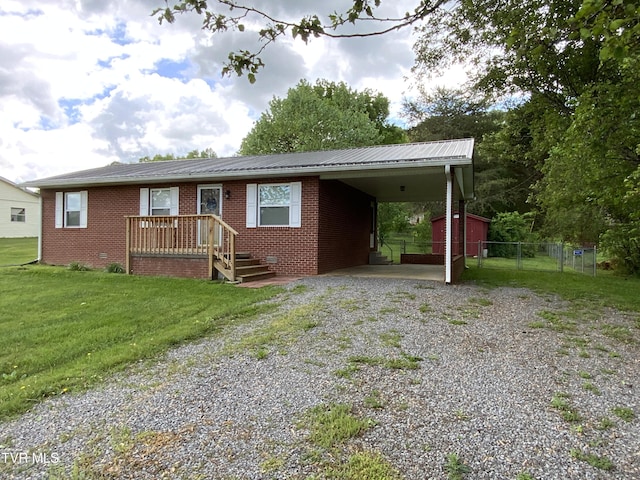 ranch-style house with driveway, metal roof, fence, a front lawn, and brick siding