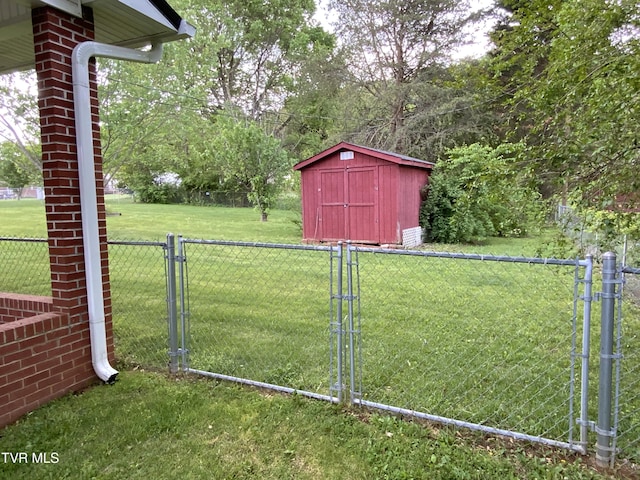 view of yard featuring a gate, fence, a shed, and an outbuilding