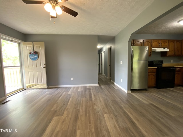 unfurnished living room featuring wood finished floors, ceiling fan, baseboards, visible vents, and a textured ceiling
