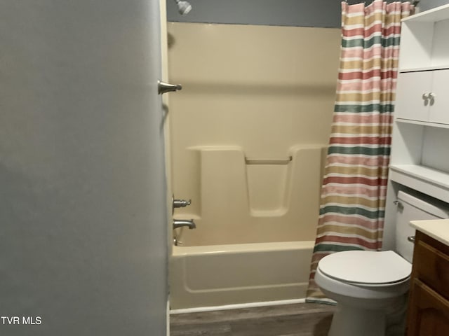 bathroom featuring toilet, vanity, shower / tub combo, and wood finished floors