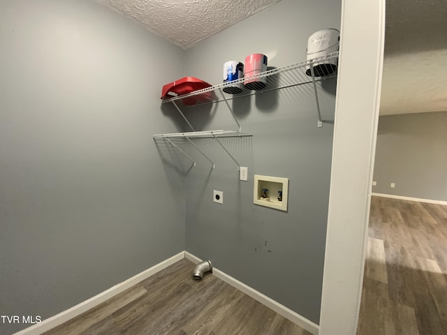 clothes washing area featuring hookup for a washing machine, wood finished floors, laundry area, electric dryer hookup, and a textured ceiling