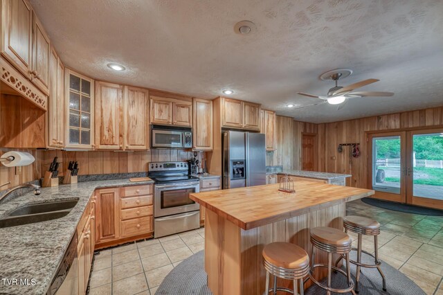 1010 Heaton Creek Rd, Roan Mountain, TN 37687 - kitchen featuring a sink, a breakfast bar area, butcher block counters, stainless steel appliances, and a kitchen island