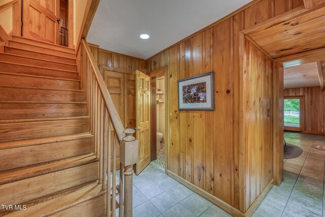 1010 Heaton Creek Rd, Roan Mountain, TN 37687 - stairway featuring wooden walls, tile patterned flooring, and baseboards