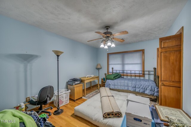 1010 Heaton Creek Rd, Roan Mountain, TN 37687 - bedroom featuring a textured ceiling, light wood finished floors, and ceiling fan
