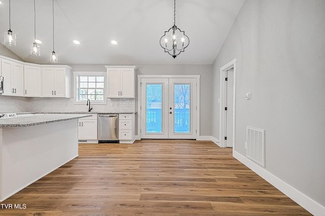 kitchen with a sink, visible vents, white cabinetry, appliances with stainless steel finishes, and lofted ceiling