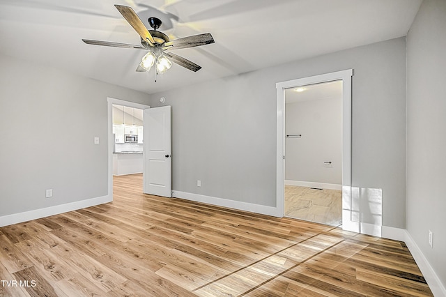 unfurnished bedroom with baseboards, light wood-type flooring, and a ceiling fan
