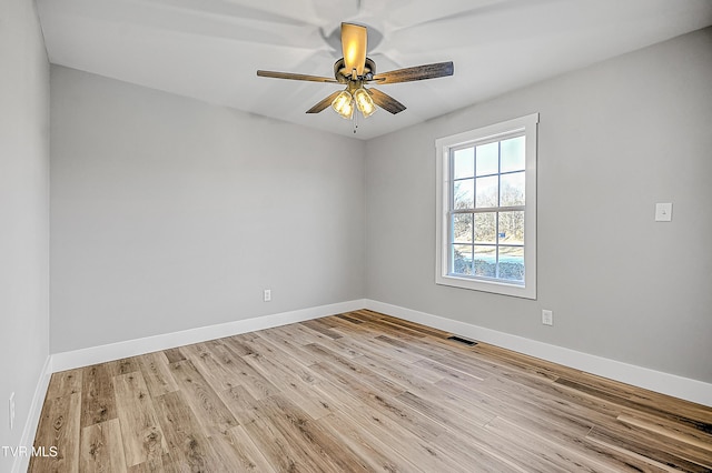 spare room with visible vents, light wood-style flooring, and baseboards