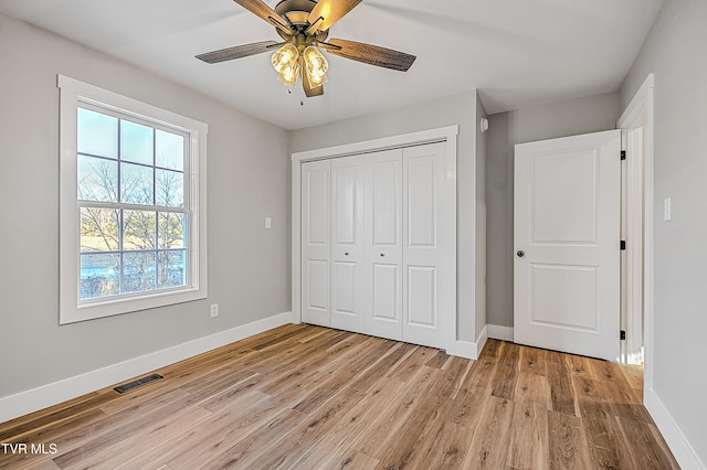 unfurnished bedroom featuring visible vents, baseboards, and multiple windows