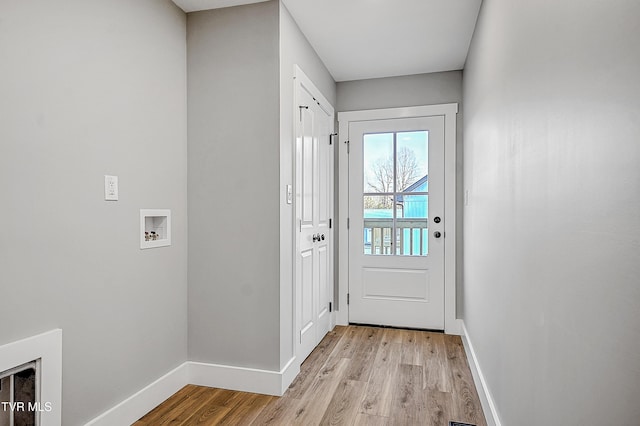 doorway to outside with baseboards and light wood finished floors