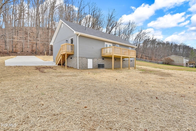 back of house with a deck, a shingled roof, and stairs
