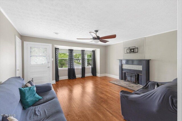 800 Pearl St, Bristol, VA 24201 - living room featuring a textured ceiling, a fireplace with raised hearth, baseboards, wood finished floors, and a ceiling fan