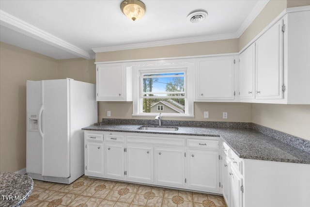 kitchen featuring white fridge with ice dispenser, ornamental molding, a sink, white cabinetry, and visible vents