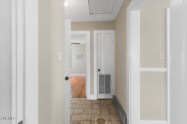 800 Pearl St, Bristol, VA 24201 - hall with a baseboard heating unit, light tile patterned floors, visible vents, baseboards, and a textured ceiling