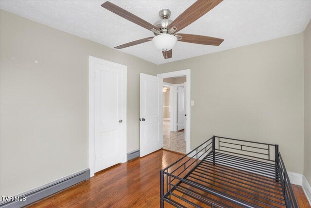 800 Pearl St, Bristol, VA 24201 - unfurnished bedroom with wood finished floors, a ceiling fan, a baseboard heating unit, and baseboards
