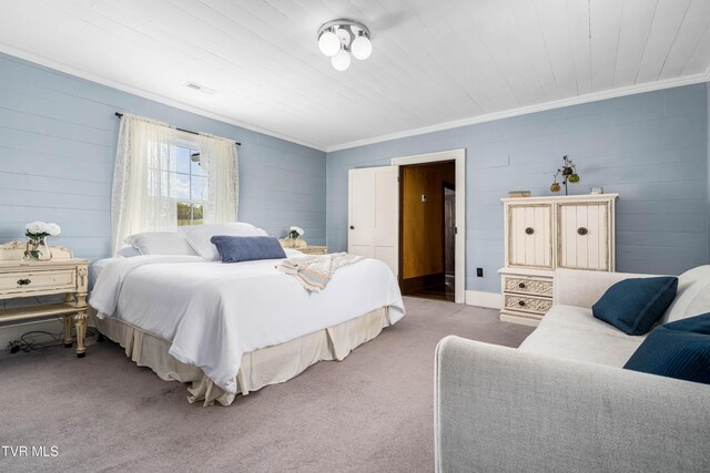 carpeted bedroom featuring crown molding, visible vents, and wood walls